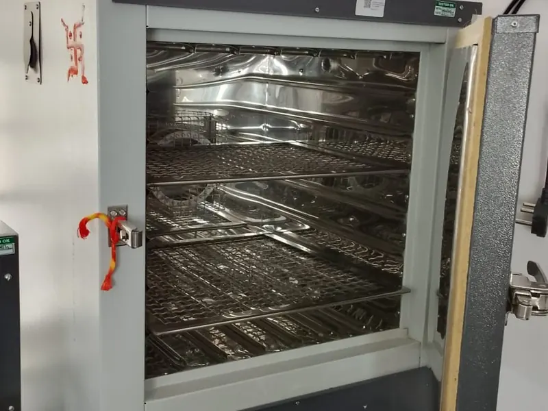 Laboratory hot air oven with sample trays for moisture determination
