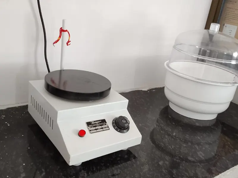 Laboratory hot plate and glass desiccator on the chemistry bench